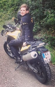 Frau auf gelbem BMW-Motorrad, Eva Strehler, Eva hin und weg, auf Weg in Wald