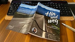 Taschenbuch "Hin und weg - Blind Date mit den Karpaten" von Eva Strehler liegt aufgeschlagen auf Tastatur