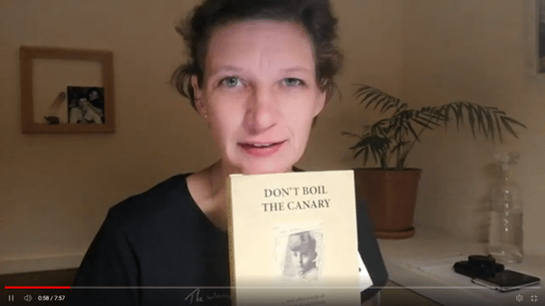 woman with book by Ted Simon, autobiography Don't boil the Canary"