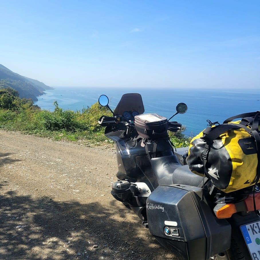 Motorrad vor felsiger Küste mit Meer